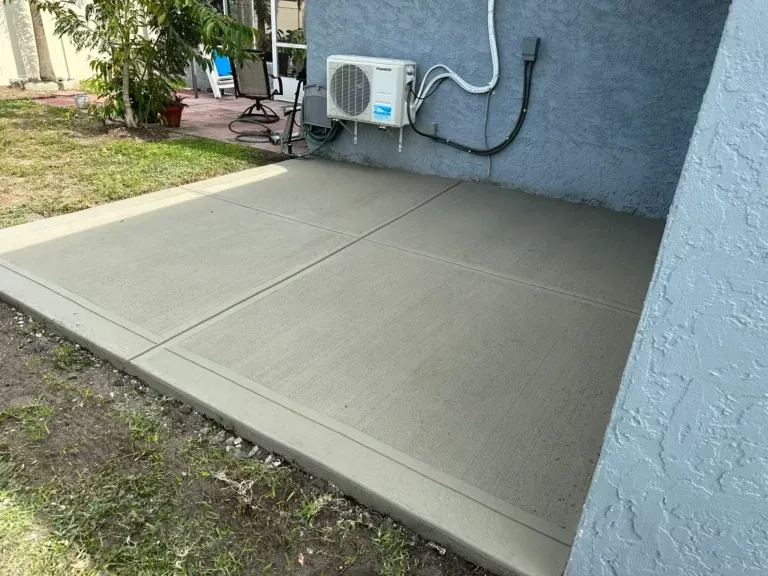 Small concrete slab pad beside a house wall with an air conditioner unit, Brooksville, FL
